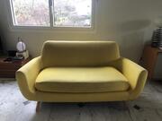 Canapé 2/3 places en tissu jaune et pieds inclinés en bois clair