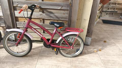 Vélo enfant mauve, roue arrière crevée.