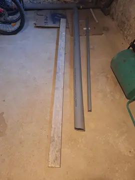 donne règle de maçon et tubes PVC