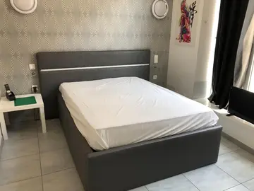 Lit avec tête de lit avec ligne lumineuse intégrée.