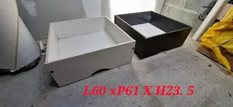 2 tiroirs à roulettes sous un lit