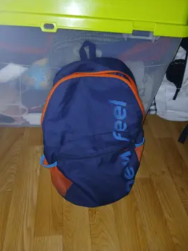 sac à dos de sport un peu abîmé bleu et un peu d'orange de pochette et sur les côtés de range boutei