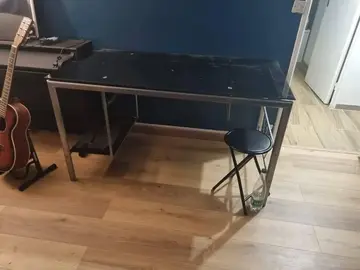 Bureau en fer et plateau en verre noir.
