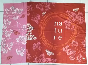 Paréo rouge yves rocher avec motifs colorés et écriture « nature ».