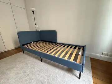 Deux lits simple IKEA Blakullen bleu, un lampadaire et un tapis