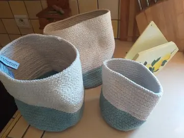 trois panieres en toile et un porte filtre a café en bois