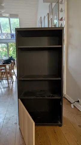 Meuble besta noir avec trois étagères et une porte poussoir