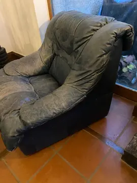 Fauteuil bleu en cuir (décoloré sur l'assise) mais encore moelleux.