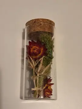 Tube en verre contenant des fleurs sèches