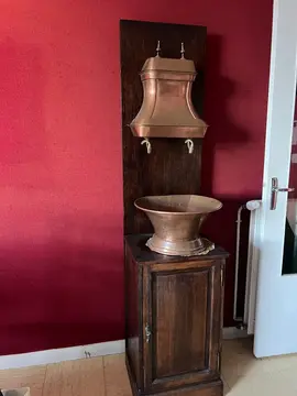 Meuble avec reserve d'eau et vasque en cuivre sur meuble en bois avec étagères