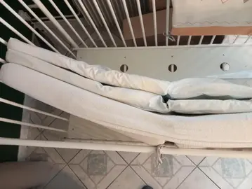 lit bébé à barreaux blancs