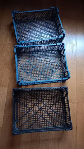3 cagettes en plastiques (2 bleues et 1 noir) s'empilent