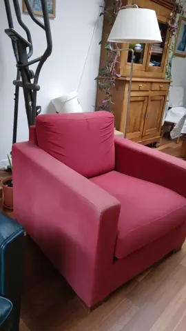 Donne un fauteuil rouge en tissu. Assise confortable