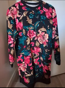 Robe à manches longues avec motif floral coloré.